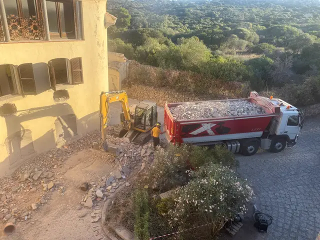 Camion carico di macerie sotto la villa in demolizione